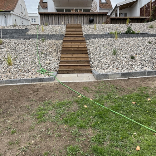 Opbygning af en stor og ny terrasse med trappe i træ og flisebelægning
